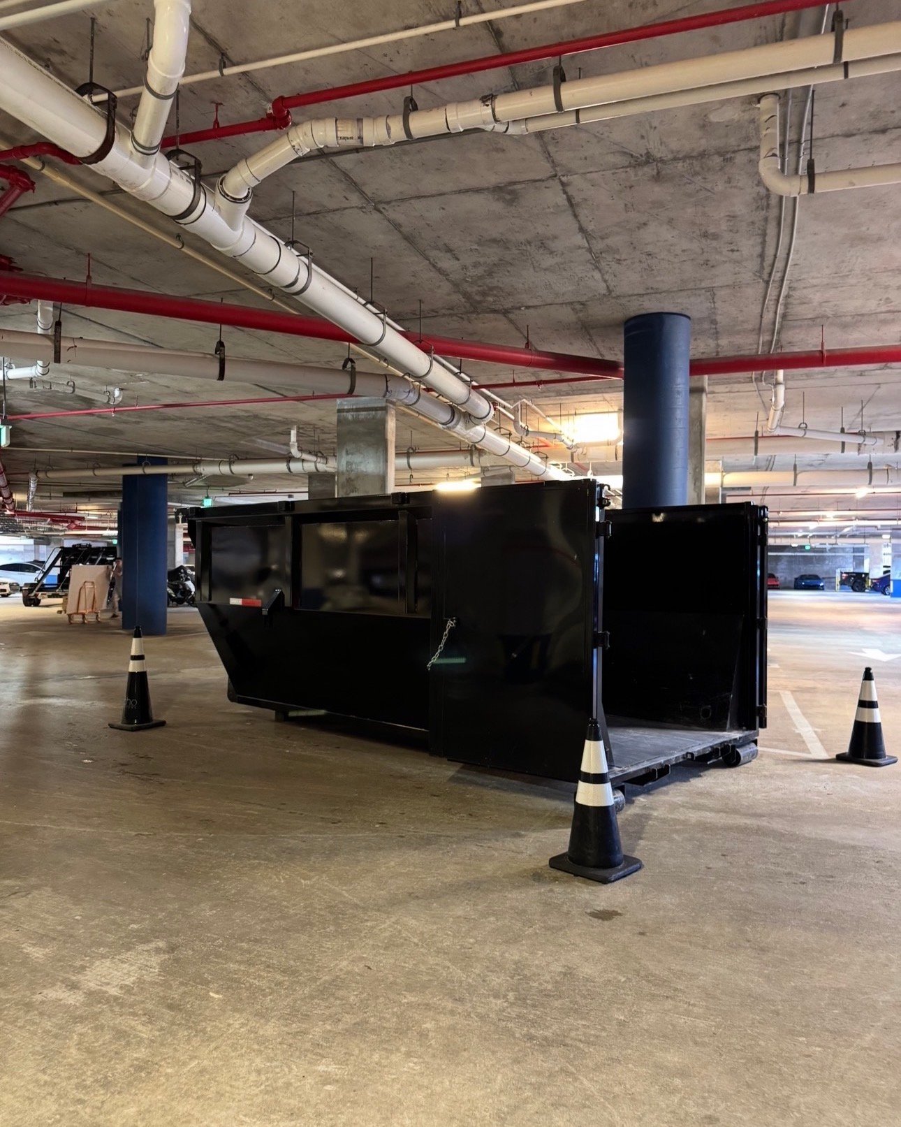 Commercial dumpster rental Miami high-rise — Barraza Industries underground parking garage placement